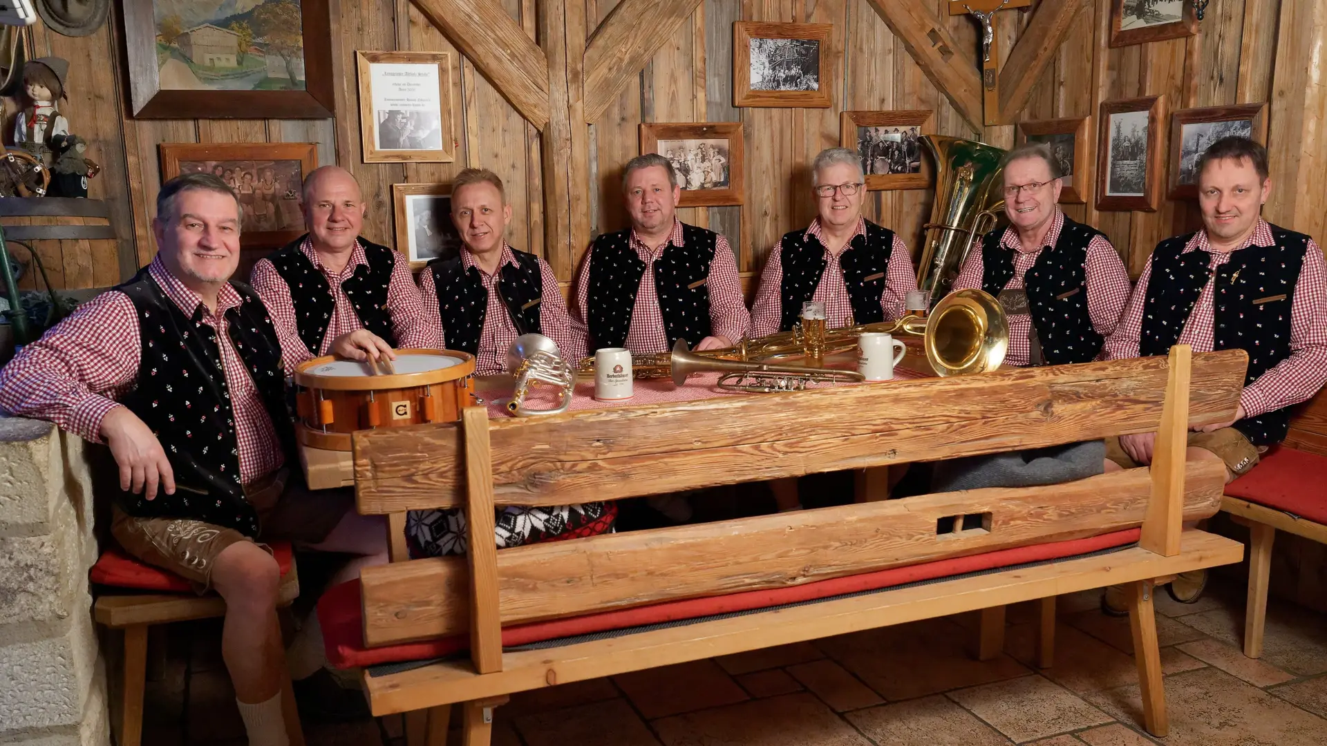 Die Musiker der Stadl Böhmischen an einem Tisch in der Stube, mit ihren Instrumenten