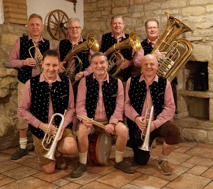 Die Musiker der Stadl Böhmischen mit ihren Instrumenten vor einer Natursteinmauer